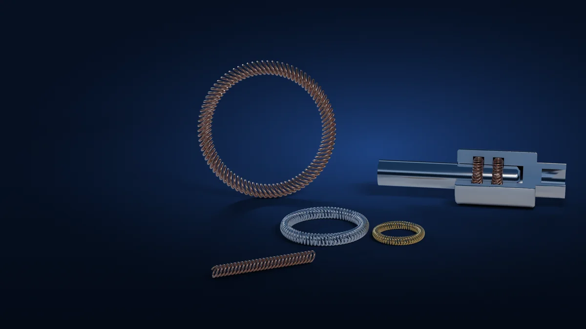 Canted coil spring rings in copper alloy, silver and gold finishes beside a sectioned connector showing spring contacts seated in the housing grooves